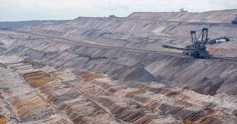 Foto ampla de um campo de mineração sustentável com uma estrutura industrial